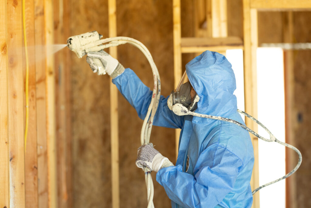 An installer adding spray foam insulation to a home.